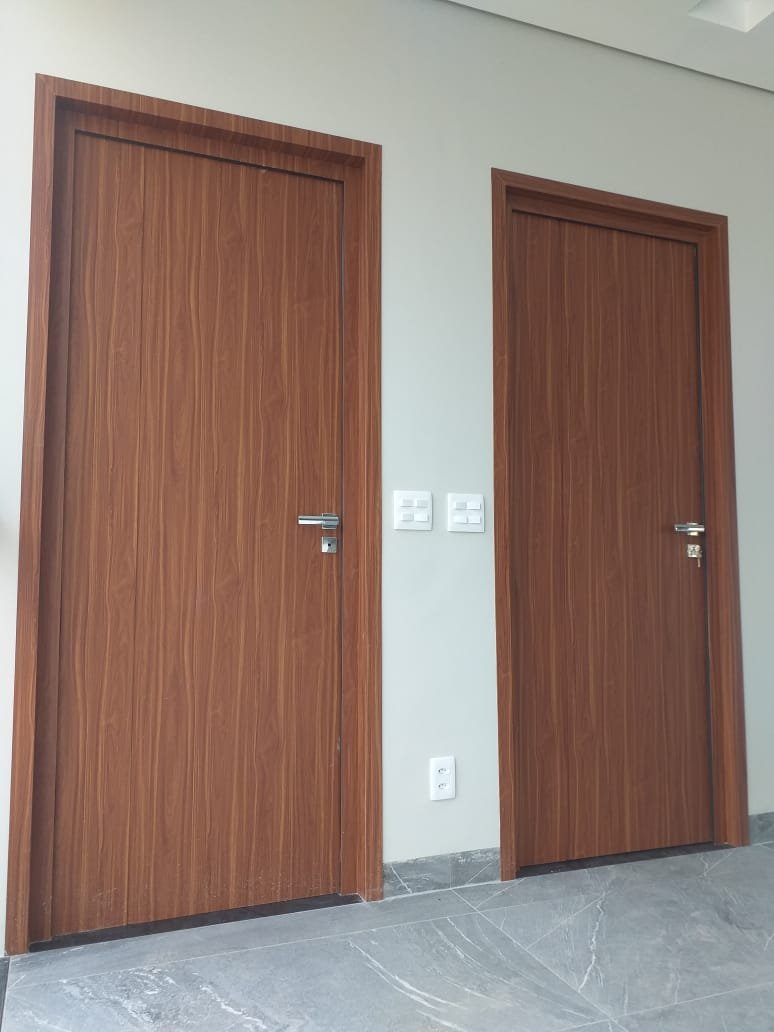Duas portas em ACM com acabamento amadeirado lado a lado, ambiente interno